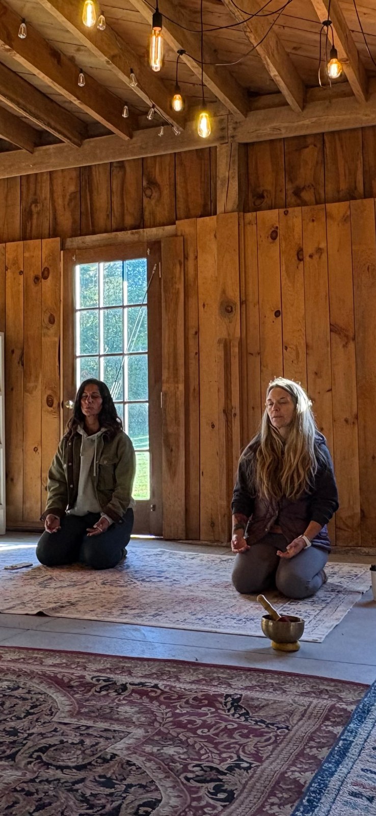 Nicole Parsons and Meg Leighton meditating together at Evergreen Farm